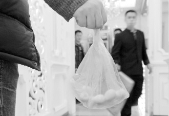 2月16日，在宁夏银川一火锅店内，一顾客将没吃完的涮品打包带走。 新华社发 李然摄